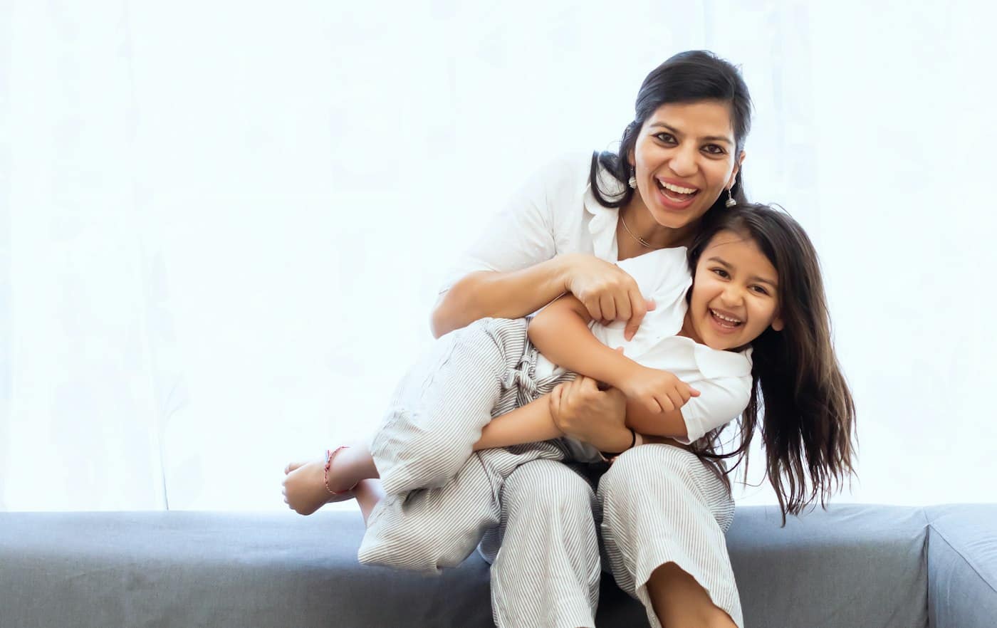 A mother and daughter laughing together at home