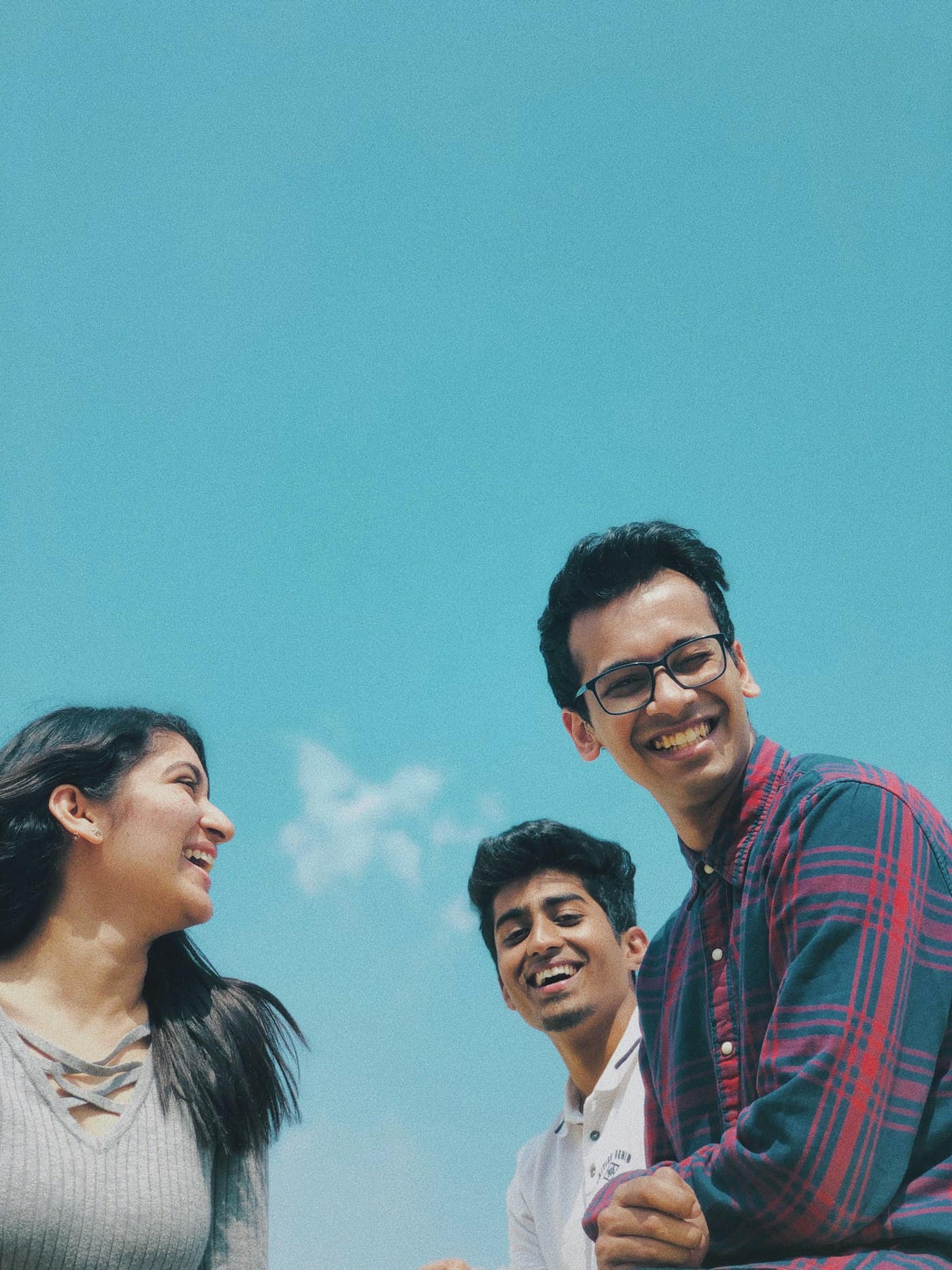 Three young people laughing together outdoors